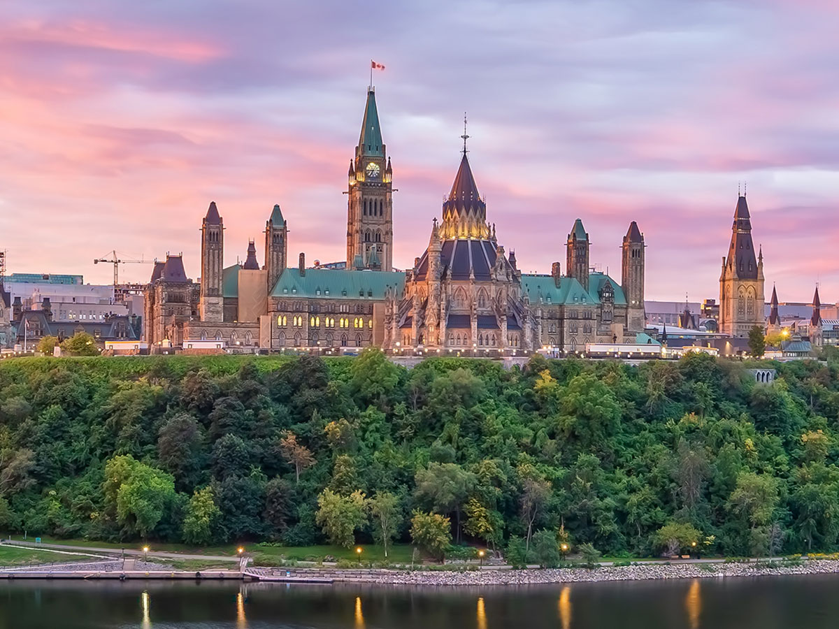 One Marketing - Client Public Services and Procurement Canada - Canadian Parliament Buildings at dusk loking over the Ottawa river